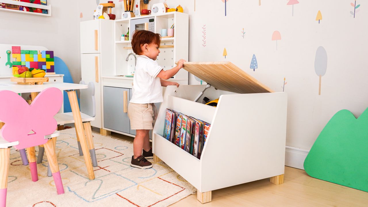 Quarto infantil organizado com baú e móveis acessíveis para a criança