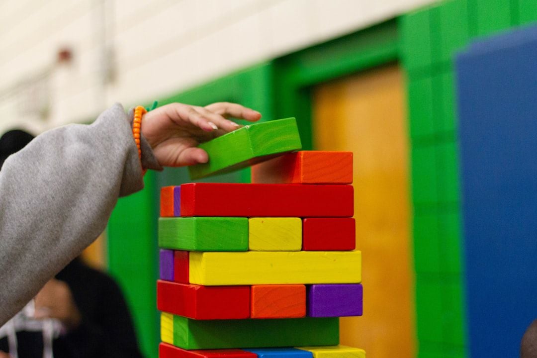 Criança empilhando blocos de madeira coloridos — atividade de blocos de construção para crianças de 4 anos