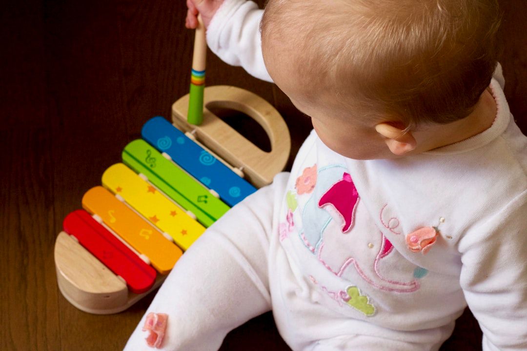 Bebê brincando com xilofone de madeira colorido — brinquedo sensorial ideal para estimular bebês de 1 ano