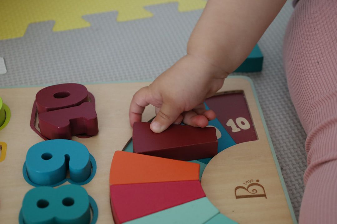 Criança brincando com brinquedos de madeira no chão — atividade de coordenação motora fina para 3 anos