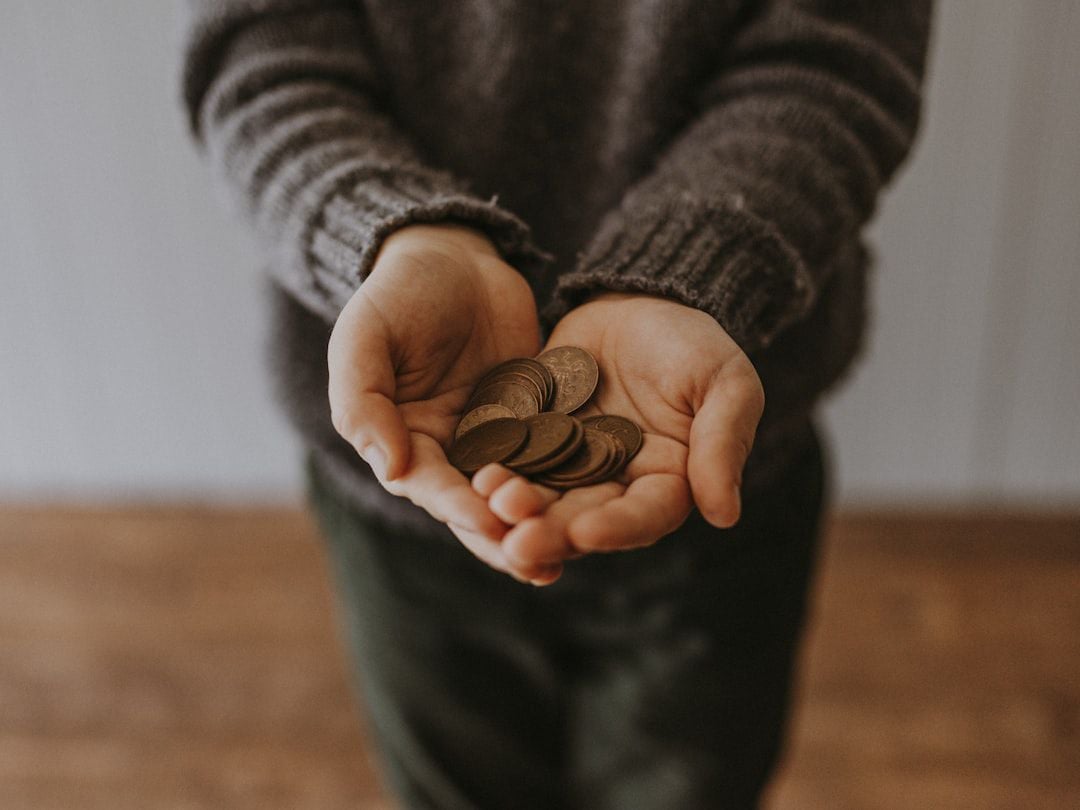 Criança segurando moedas nas mãos — educação financeira para crianças com mercadinho de brinquedo