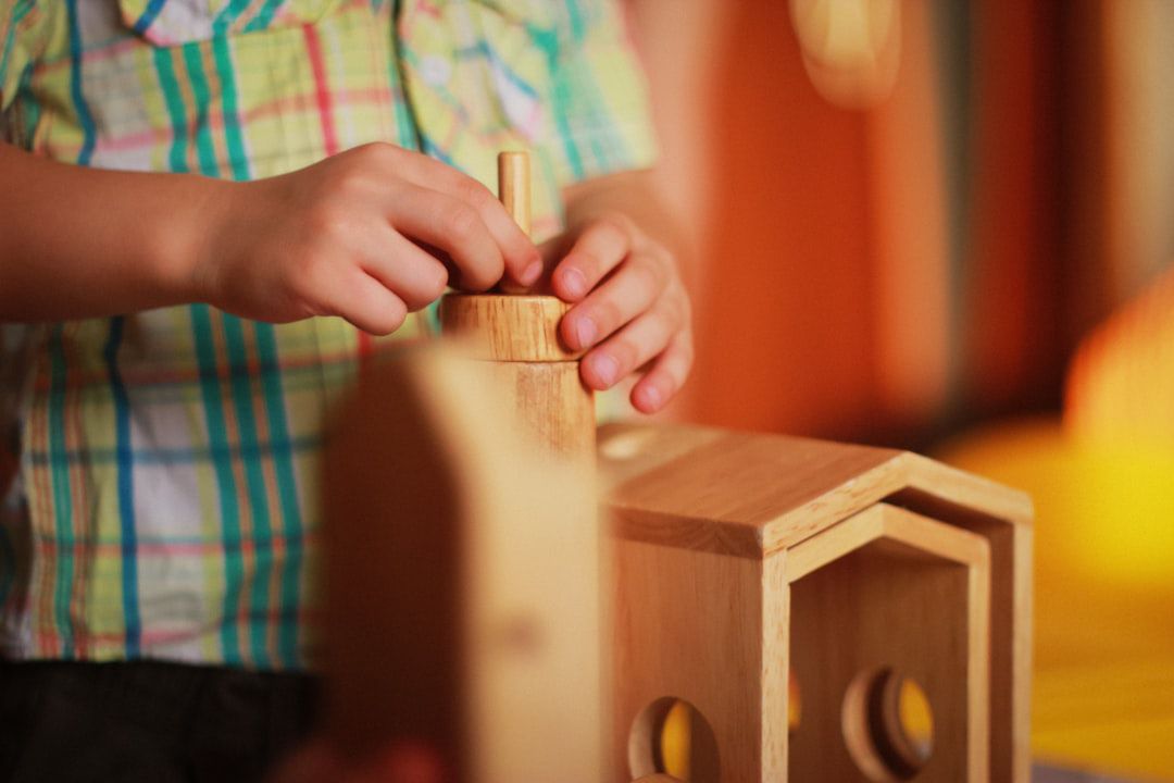 Mãos de criança encaixando peças de um brinquedo de madeira — presente para criança de 6 anos